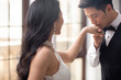 © Blue Jean Images - Happy young Chinese man kissing wife's hand at home