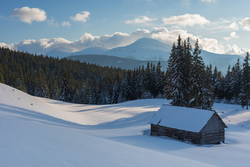 Wall Mural - Charming snow-capped houses on a mountain Carpathian mountain valley, with magnificent views of peaks in winter.