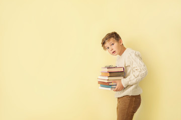 Sticker - Surprised little boy with books on color background