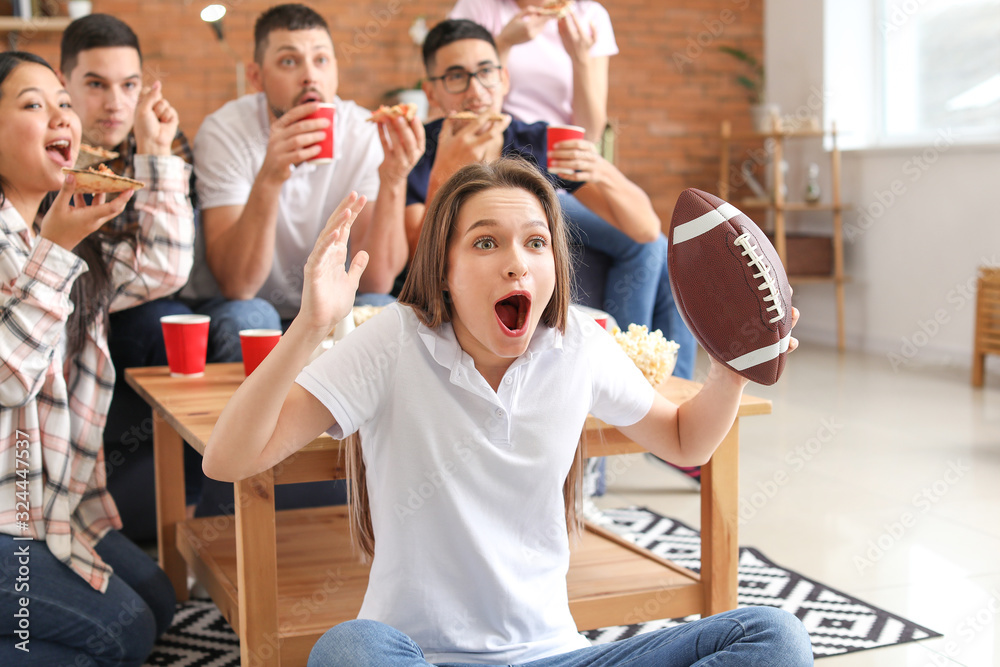 Young woman with friends watching rugby on TV