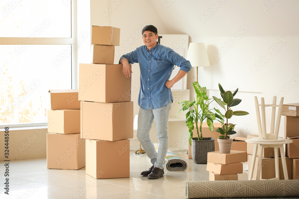 Asian man with belongings at home on moving day