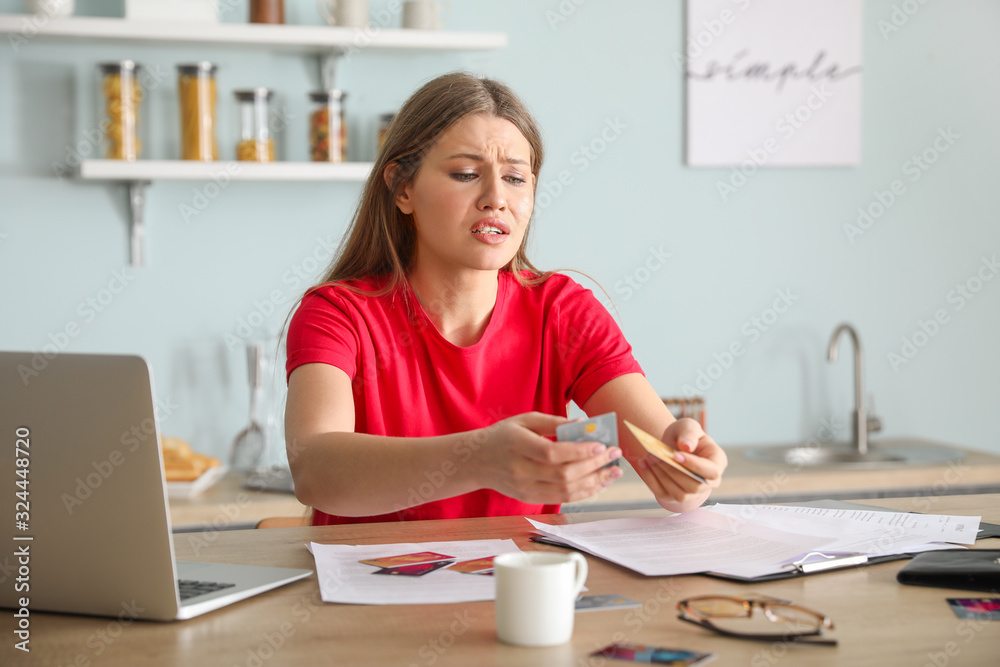 Worried young woman in debt at home