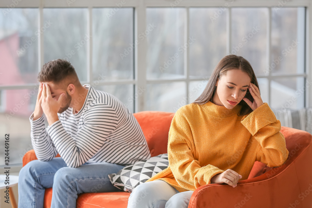 Upset young couple after quarrel at home