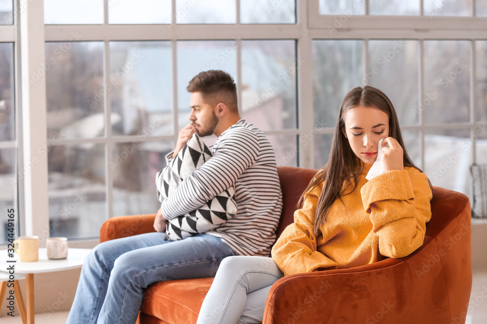 Upset young couple after quarrel at home