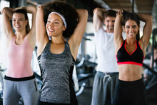 Beautiful Fit People Exercising Together In Gym