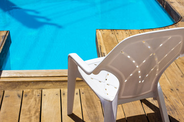 Wall Mural - pool side chair plastic white rustic furniture object outside exterior space advertising wallpaper background concept sunny bright lighting