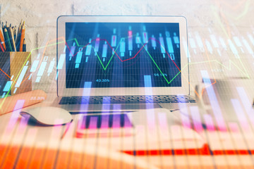 Stock market chart hologram drawn on personal computer background. Double exposure. Concept of investment.