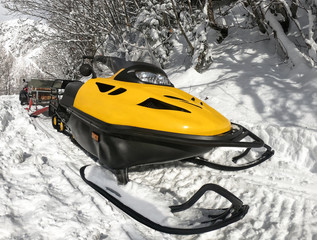 Wall Mural - Yellow snowmobile on snow at winter sunny day