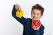 Junge freut sich über gelbe und rote Paprikaschote, freigestellt Hintergrund weiß