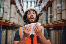Young Caucasian Warehouse Supervisor Sneezing While Feeling Sick Of Cold