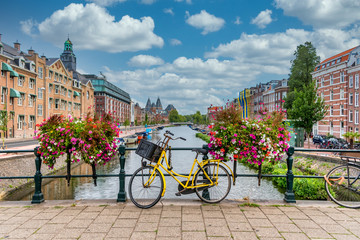 bicycle on a bridge over a canal in amsterdam netherlands with blue sky