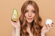 © Drobot Dean - Portrait of young half-naked woman holding avocado and face cream jar