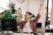 © JustLife - Attractive businessman in office. Young programmer with headphones singing at work.