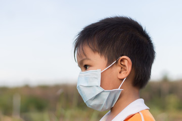 portrait image of asian child boy wearing a protection mask​ for​ prevent​ corona​ virus​ or​ dust p