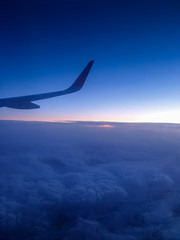 Wall Mural - Beautiful image of airplane wing flying over the clouds at sunset