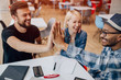 © kegfire - Cheerful young colleagues giving high five with hands
