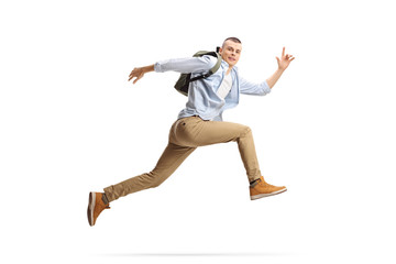 male student with backpack jumping