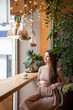 © dtatiana - Pregnant woman sitting with cup of tea inside cafe
