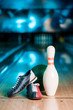 selective focus of bowling shoes, ball and skittle on bowling alley