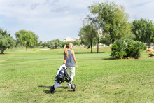 Blonde Girl With Sunglasses Dragging A Golf Cart In The Middle Of A Golf Course