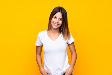 Wall Mural - Young woman over isolated yellow background laughing