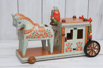 Old russian handicraft, handcraft: traditional national wooden Vologda toy - carriage with horses and driver. Russian style in folk art. Vintage souvenir from Russia. Ethnic craft. Photo on white