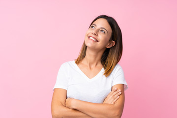 Poster - Young woman over isolated pink background looking up while smiling