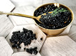 Fresh black caviar on a golden spoon. Tasty appetizer.
