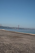 view of the beach and bridge in lisbon