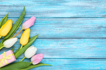 Wall Mural - Tulip flowers with gift box on blue wooden table