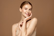 Leinwandbild Motiv Skin care model. Beautiful young woman with perfect skin touching her face and posing against beige background. Beauty treatment and spa concept.