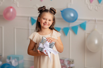 Wall Mural - Happy birthday Portrait of a happy cute blonde 7-8 years old in a festive decor with confetti and gifts.