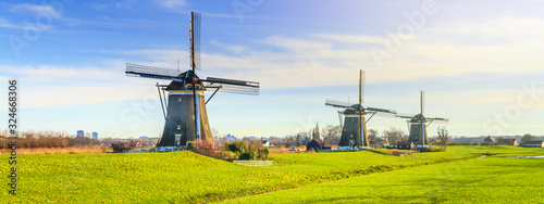 Fotografía Rural landscape - view of green meadow on background of the mills on a sunny day