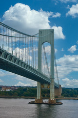 Poster - An old suspension bridge rising over a shipping channel