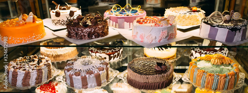 Fotografía Pastry shop glass display with selection of cream or fruit cake.