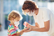 Leinwandbild Motiv Mother and child with face mask and hand sanitizer