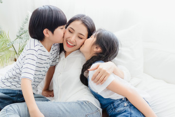 lovely happy asian family at cozy home. son and daughter kiss mother with enjoy ,relax and playful t