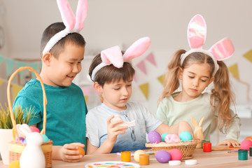 Little children painting Easter eggs at home