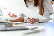 Focus on tender female hands holding important business documents with significant charts and graphs used for special corporation analysis. Accounting office concept. Blurred background