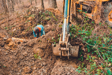 An excavator in the forest digs a ladle for fish breeding.