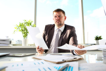 Male in suit and tie hold in arm papers at office workplace portrait. White collar worker at workspace officer highly smart serious income profit strategy headhunter offer important paperwork concept