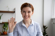 © fizkes - Head shot portrait of attractive smiling businesswoman waving hand