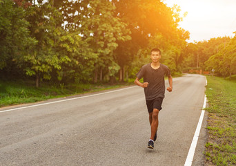 Wall Mural -  Young black runner man running on the street be exercise and workout in nature countryside road in the morning. Healthy body exercise sports concept.