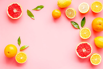 Wall Mural - Fresh citrus frame. Oranges, tangerines, grapefruits, leaves on pink background top-down copy space