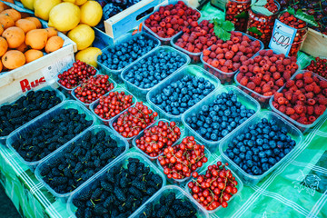 Wall Mural - A mix of fresh berries on the market, strawberries, blueberries, raspberries, blackberries, cherries and red currants