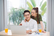 © makistock - Book online. Happy attractive woman hugging man while he using laptop