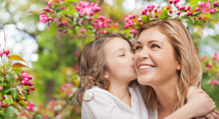 family, motherhood and people concept - happy daughter kissing and hugging smiling mother over cherr