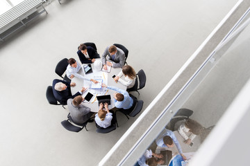 construction business, architecture and building concept - group of architects with blueprint discussing report at office