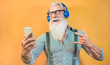 © DisobeyArt - Senior hipster man using smartphone app for creating playlist with rock music - Trendy tattoo guy having fun with mobile phone technology - Tech and joyful elderly lifestyle concept - Focus on face