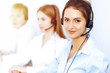 © rogerphoto - Call center operators. Focus on beautiful business woman using headset in sunny office